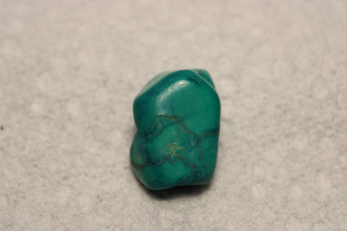 Polished blue-green stone with black veins.